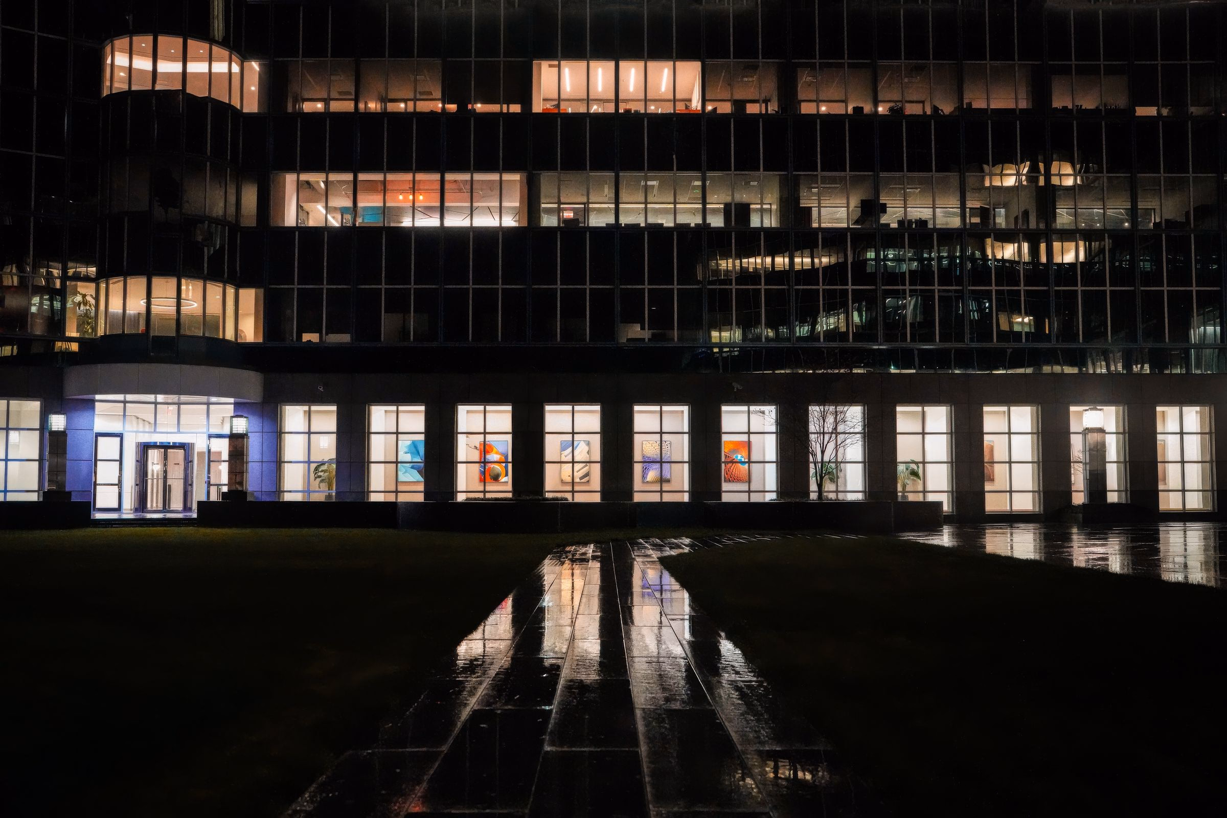 An illuminated commercial building at night with reflections on wet pavement after a Cleveland install