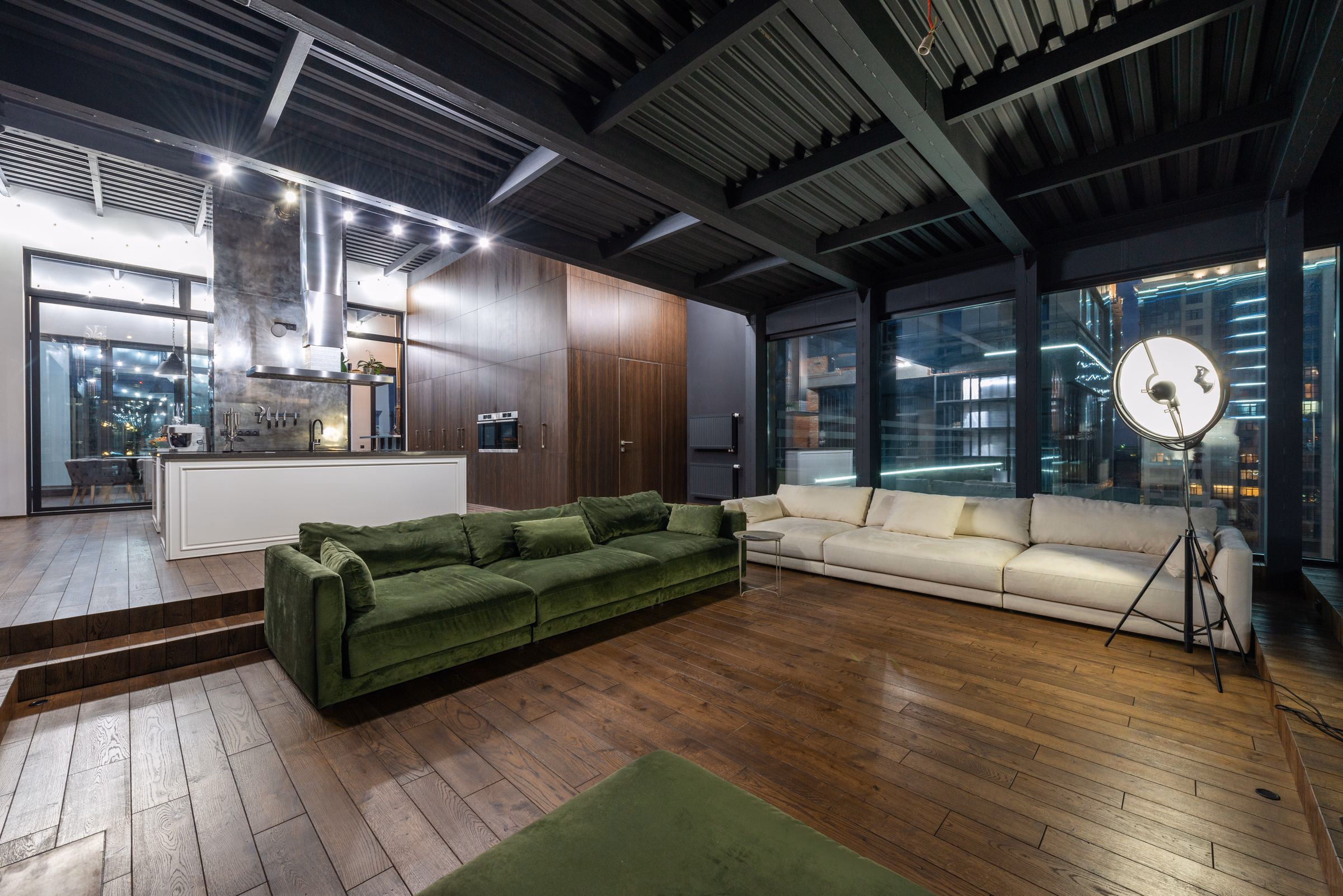 Lit modern loft interior at dusk, looking out toward the city.